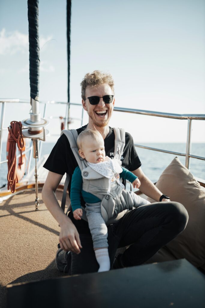 Brand Development for Baby Product Companies 6 Father and baby smiling on a sunny boat trip, enjoying the ocean breeze and sunlight.