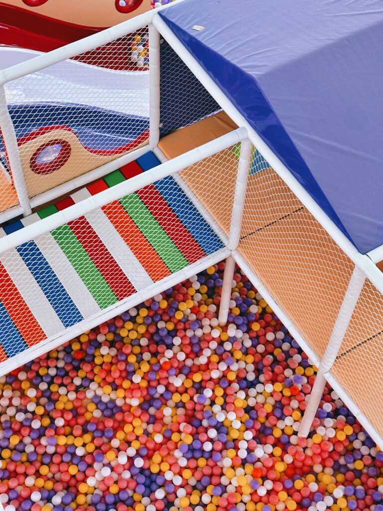 Espacios de Crianza y Centros Familiares 2 Vibrant indoor playground with ball pit and climbing nets, perfect for kids' fun.