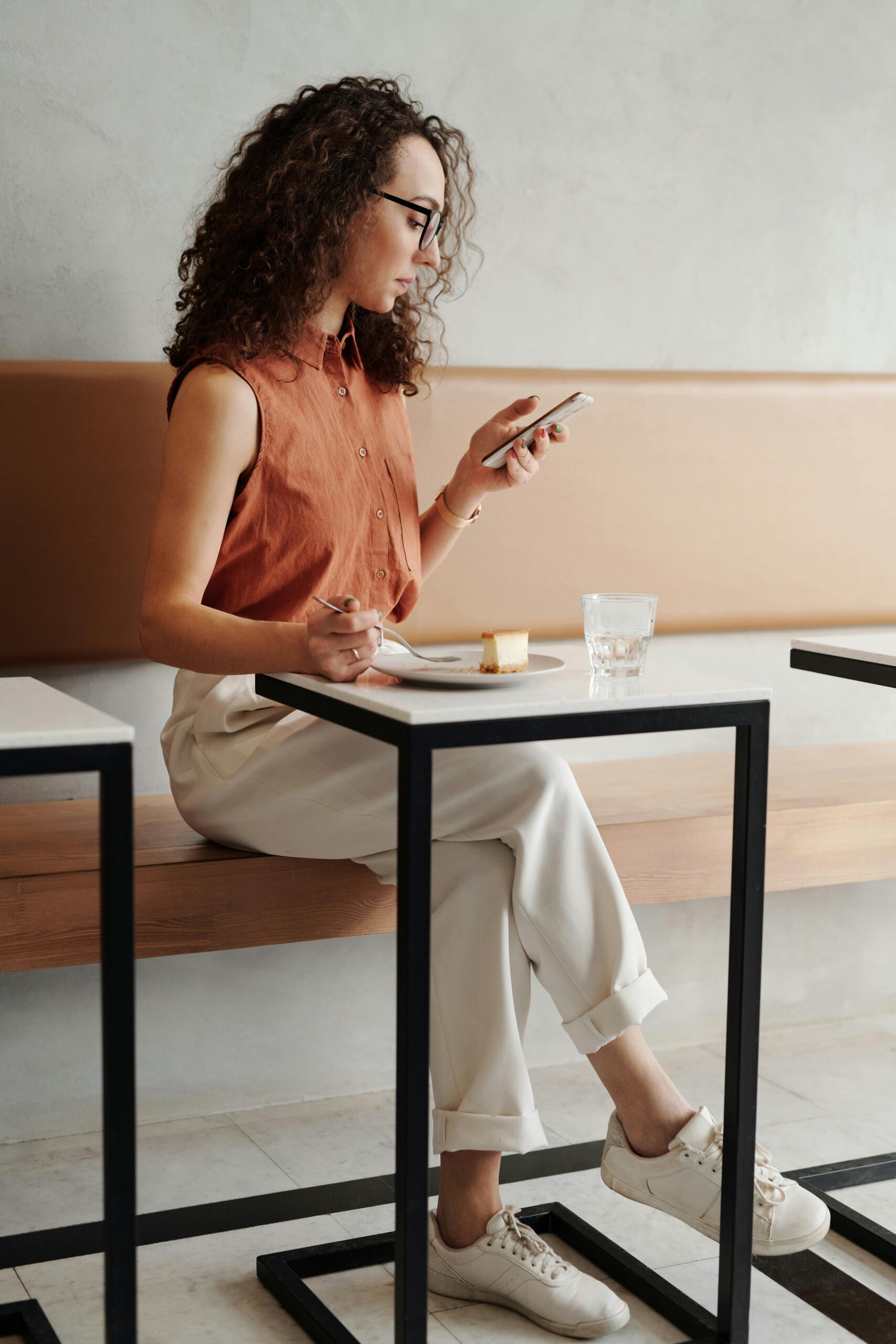 Social Media Marketing for Children's Brands 1 A young woman enjoys a quiet moment at a coffee shop, checking her phone while seated.