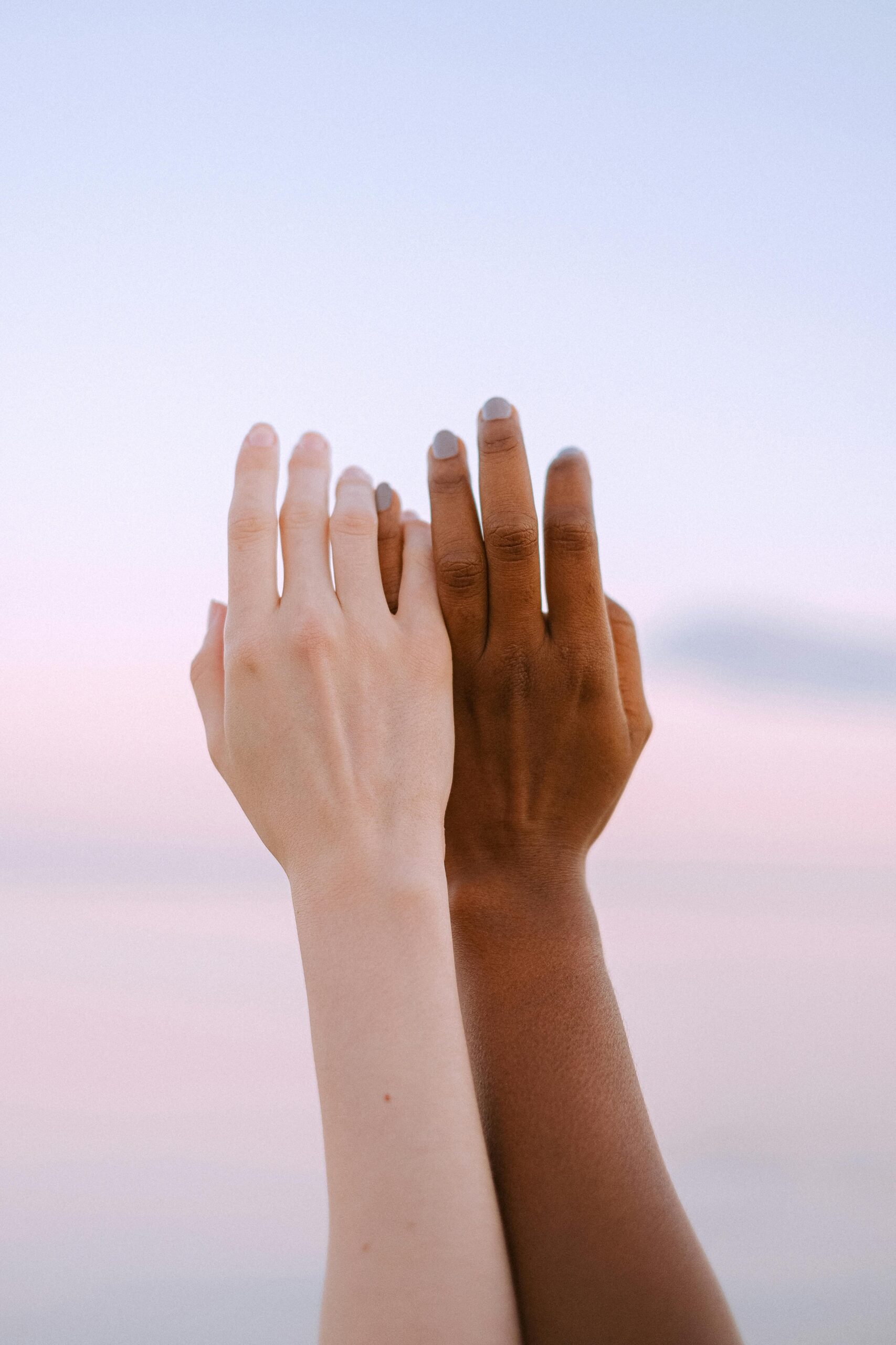 SEO 5 Two hands of different ethnicities reaching towards the sky, symbolizing unity and diversity.