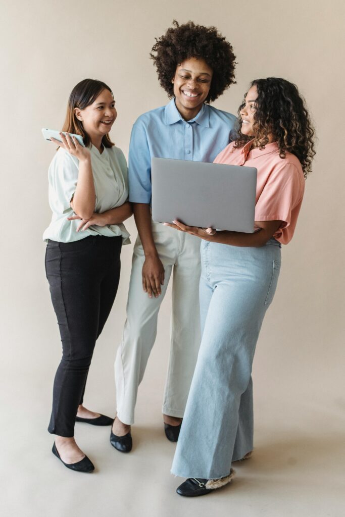 Amazon & Marketplace Marketing 6 Three women of different ethnicities smiling while sharing ideas around a laptop.
