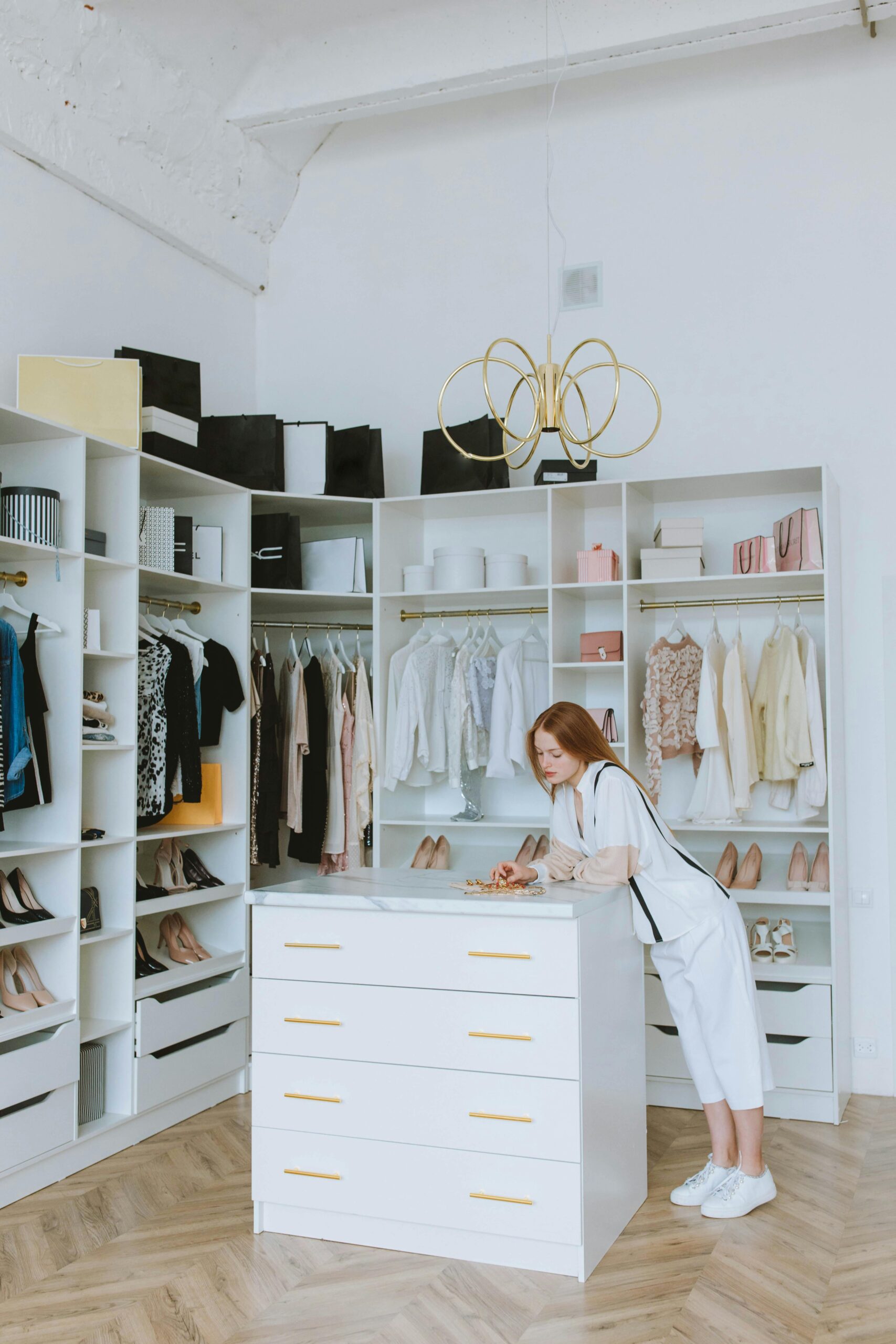 Strollers and Baby car seats 4 Elegant wardrobe with a red-haired woman organizing clothes in a modern fashion boutique.