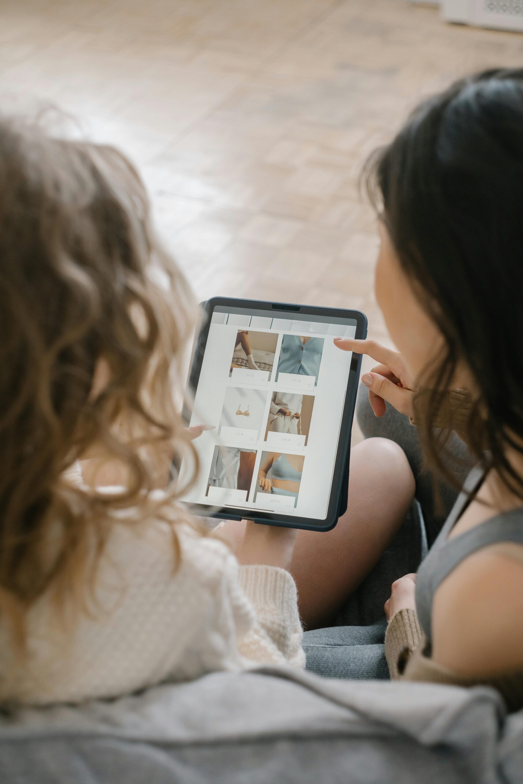 Amazon & Marketplace Marketing 2 Two women sitting together, shopping online using a tablet, sharing ideas and browsing products.
