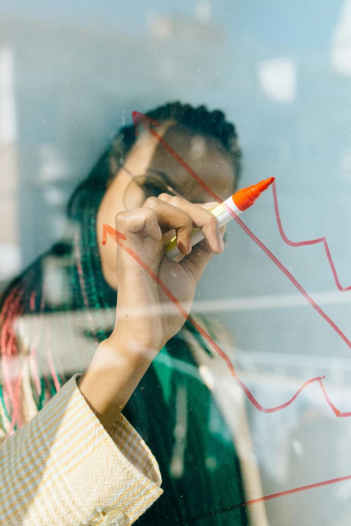 Espacios de Crianza y Centros Familiares 3 A businesswoman draws a red financial graph on a glass panel, symbolizing strategy and success.