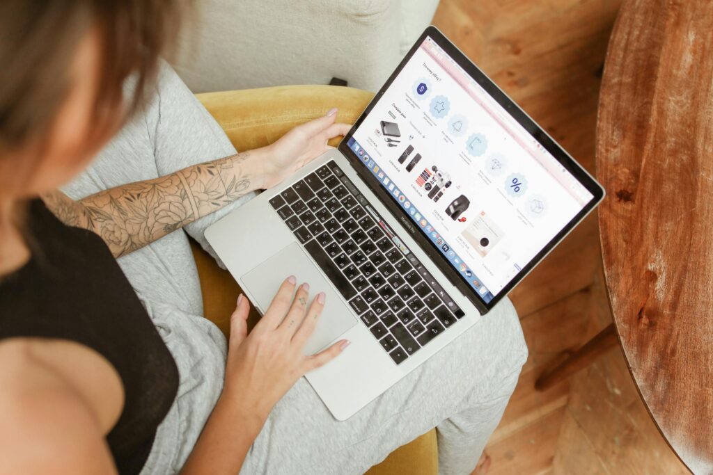 Google Ads for Baby Ecommerce Brands 5 Woman with tattoos browsing online shopping site on a laptop indoors