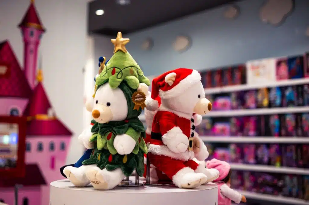 SEO para tiendas de juguetes: cómo ganar visibilidad y ventas 7 Adorable stuffed bears in Christmas attire on display in a vibrant toy store setting.