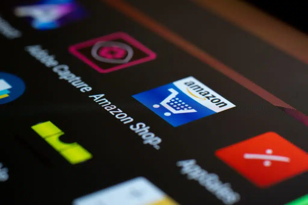 FBA o FBM para vender productos infantiles en Amazon España 5 Close-up of the Amazon shopping app icon on a smartphone screen. Ideal for online shopping and technology themes.