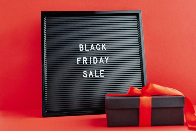 Black Friday sale display with gift box on a vibrant red background, perfect for shopping promotions.