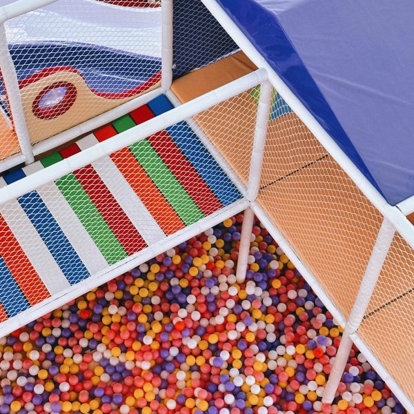 Vibrant indoor playground with ball pit and climbing nets, perfect for kids' fun.