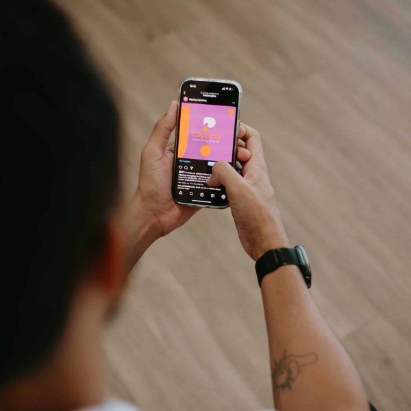 An individual using a smartphone indoors, engaging in mobile application interaction.