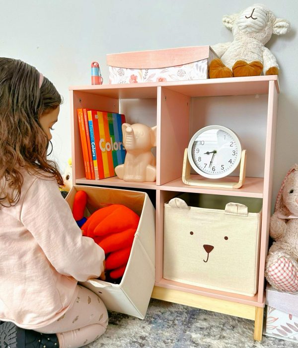 A child organizes toys on a colorful shelf in a cozy nursery setting.