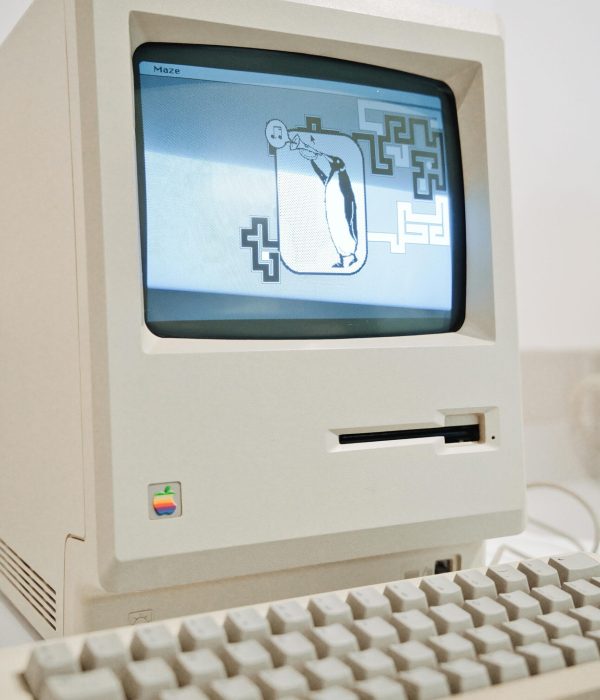 Classic Macintosh computer displaying a retro game, highlighting vintage tech charm.