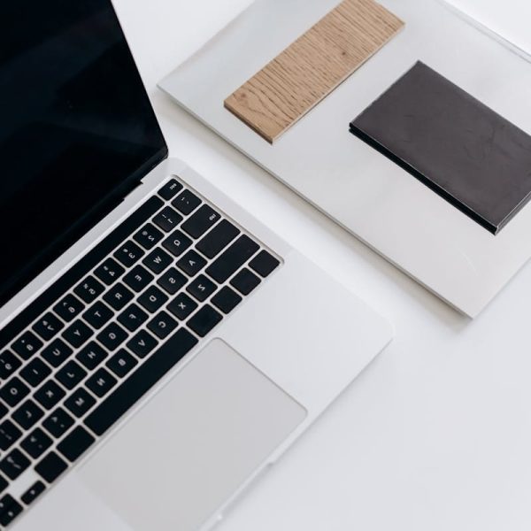 Elegant minimalist workspace featuring a laptop and notebooks on a sleek desk.