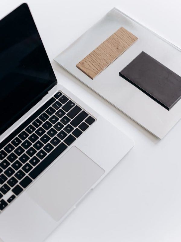 Elegant minimalist workspace featuring a laptop and notebooks on a sleek desk.