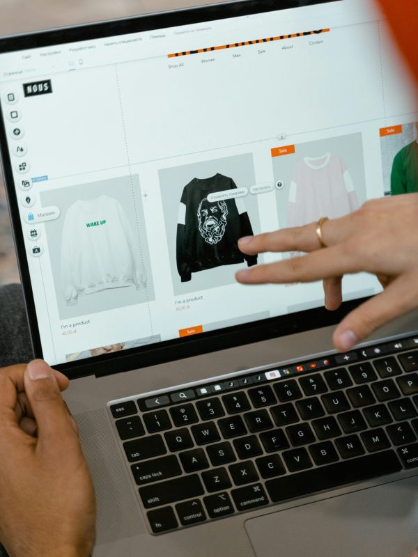 Primer plano de manos interactuando con un sitio web de compras en la pantalla de un portátil en interiores.
