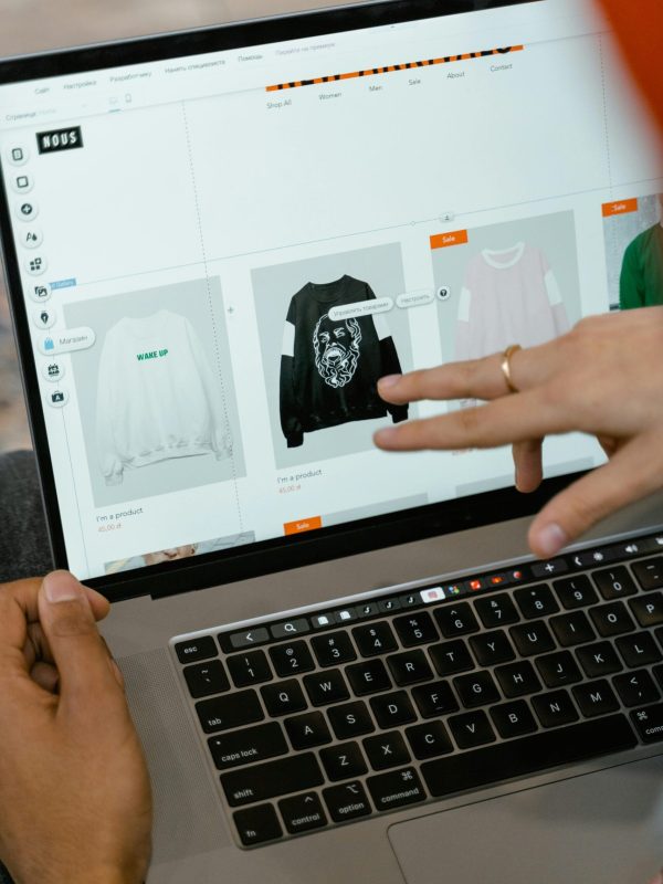 Primer plano de manos interactuando con un sitio web de compras en la pantalla de un portátil en interiores.