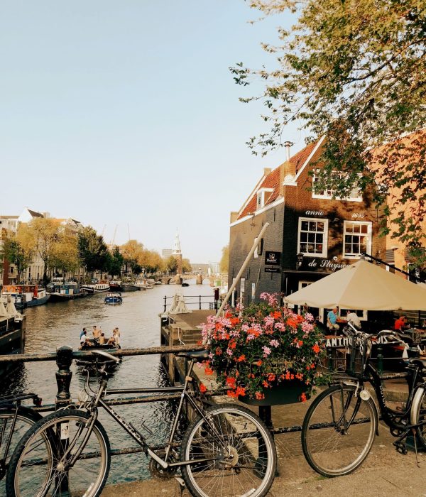Charming view of Amsterdam's canal with bicycles and historic buildings in autumn.