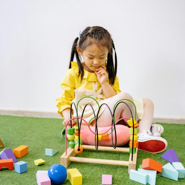 A young girl plays with educational toys, stimulating learning and creativity indoors.